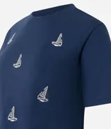Remera azul marino de algodón con cuello redondo y mangas cortas. Presenta un estampado de barcos de vela blancos.