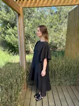 Vestido largo color beige, de corte amplio, con mangas cortas abullonadas y volado en el ruedo.