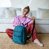 Mochila color beige de tafeta con apertura superior con cierre y tiradores metálicos. Incluye bolsillos internos, bolsillo con doble cierre metálico al frente, asas rígidas de mano y correas regulables para colgar en la espalda.