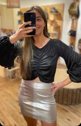Blusa dorada de lamé elastizado, con frunce central y mangas largas abullonadas en los puños.