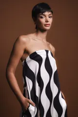 Vestido largo strapless con estampado abstracto en blanco y negro, con elástico en la parte trasera y bolsillos laterales. Incluye una pieza de tela roja para usar como chalina.