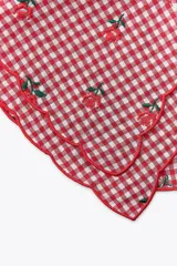 Cuello desmontable con estampado de cuadros vichy rojos y blancos, detalle de flores bordadas y volados en el borde. Se ata al frente con lazos del mismo tejido.