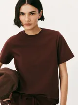 Remera color marrón claro, de corte recto, con cuello redondo y mangas cortas.