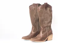 Botas de cuero color marrón con caña alta, punta fina y taco de madera.