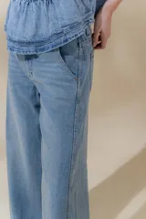 Pantalón de jean azul de pierna ancha y tiro medio, con cinco bolsillos y pespuntes a contratono.