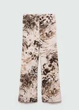 Pantalón wideleg con estampado animal print en tonos beige, marrón y negro. Tiene tiro medio y cierre de cremallera invisible en el lateral.