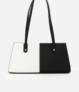 Cartera shoulder mediana de cuero sintético, con diseño bicolor blanco y negro y detalles metálicos dorados.