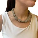 Collar corto con cuentas de hilo de diferentes formas y detalles dorados.