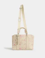 Cartera tipo tote color blanco crudo, con doble asa corta y correa larga regulable y desmontable. Incluye charm colgante con forma de corazón y cierre superior.