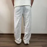 Pantalón de lino color beige, de corte recto, con cintura ajustable con cordón.