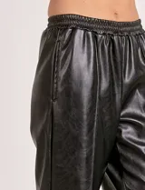 Pantalón de eco cuero color marrón, marca Elan, con pretina elastizada, bolsillos delanteros, pierna recta y costura frontal.