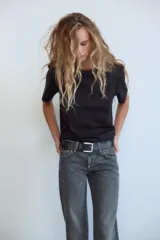 Jeans de mezclilla azul oscuro con efecto lavado, tiro bajo y pierna ancha extra larga. Modelo de cinco bolsillos con cierre frontal de cremallera y botón metálico.