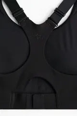 Top deportivo negro de soporte alto, confeccionado en tejido funcional ShapeMove™ y DryMove™. Cuenta con copas forradas con relleno extraíble, breteles anchos ajustables, espalda nadadora de malla y cierre de corchetes.