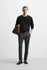 Pantalón negro de corte slim fit, confeccionado en tejido elástico. Cuenta con cintura elástica, bolsillos frontales y traseros de vivo. Cierre frontal con cremallera y botón.