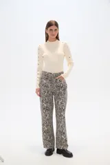 Pantalón ancho de algodón con estampado abstracto en tonos beige y negro, de tiro alto y con bolsillos laterales.