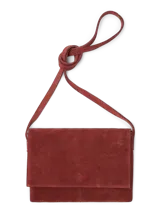 Bolso bandolera color marrón óxido, con solapa y cierre de botón y cremallera. Tiene correa larga con nudo decorativo y bolsillo interior con cierre.