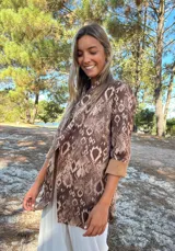 Parka o chaqueta ligera de manga larga con estampado de piel de serpiente en tonos marrones y beige. Presenta un cuello tipo solapa y puños anchos de color camel liso.