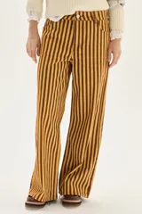 Pantalón de jean tiro medio, corte wide leg, con estampado de rayas verticales en tonos amarillo mostaza y marrón oscuro.