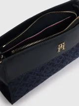 Bandolera Tommy Hilfiger azul marino con estampado de logos, correa ajustable y logo metálico dorado en el frente.