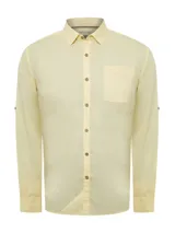 Camisa de manga larga color amarillo pálido, confeccionada en popelina de algodón orgánico. Cuenta con botones de madera, mangas ajustables, bolsillo de pecho con logo bordado y protección UPF +20.