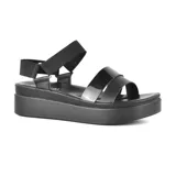 Sandalias negras de plataforma con tiras anchas de charol y ajuste con hebilla en el tobillo.