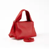 Bandolera roja de cuero sintético con correa larga regulable y asa corta.