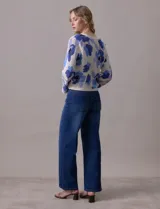 Cárdigan tejido calado color beige con estampado floral en tonos de azul y lila. Escote en V y cierre frontal con lazo.