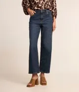 Pantalón de jean de corte recto con cintura alta, color azul oscuro, con bolsillos delanteros y traseros. Se ajusta a la cintura con cinturón de cuero marrón.
