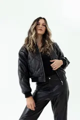Campera bomber negra de cuero ovino con diseño acolchado y cierre frontal metálico. Presenta rib en cuello, puños y cintura.