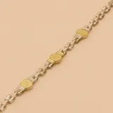 Pulsera de eslabones plateados con medallas redondas doradas de San Benito.