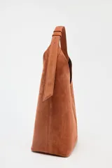 Bolso hobo de gamuza color marrón con asa de hombro ajustable.