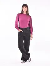 Polera color fucsia de mangas largas abullonadas y cuello alto.