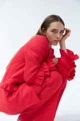 Blazer color beige confeccionado en lino, con cuello solapa, cierre frontal con un botón y mangas largas con volantes en capas.