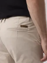 Pantalón chino color beige, de corte recto y tiro medio. Confeccionado en algodón y elastano.