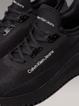 Zapatillas urbanas Calvin Klein Jeans modelo Eva Runner, color negro, confeccionadas en malla reciclada y material sintético, con logo en el lateral.