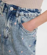 Minifalda de jean celeste con bordado de flores pequeñas en tonos rosa y celeste.