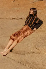 Sweater tejido a mano de algodón con cuello alto y diseño con rayas diagonales en color naranja y detalles en cuero natural.