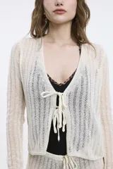 Cardigan marrón de tejido de punto calado, con escote en V y cierre frontal con lazos.