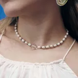 Gargantilla de perlas de río con cuentas de cristal transparente y detalles en color violeta.