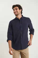 Camisa azul marino de lino y algodón, con cuello abotonado, manga larga con puños enrollados, bolsillo de parche en el pecho y cierre frontal con botones.