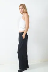 Top blanco de punto con diseño asimétrico y cuello tipo bufanda.