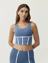 Top deportivo cropped azul con tirantes anchos y escote redondo. Diseño bicolor con vivos blancos a contraste estilo corsé.
