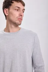 Remera manga larga gris claro, de corte recto y cuello redondo.