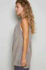 Top sin mangas color beige con escote en V y cordones cruzados. Presenta detalles de encaje en los laterales y en el ruedo.