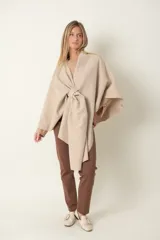 Capa de paño liso en color beige, con presilla para sujetarla, ideal para abrigar en temporadas frescas.