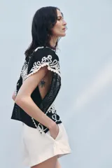 Top de Zara Woman Collection, color negro con apliques de crochet en color crudo. Cuello redondo y manga corta caída. Cierre en la espalda con abertura y botón.