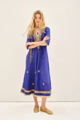 Vestido largo azul con escote en V, confeccionado en viscosa y bordado con piedras e hilos de lurex dorados.