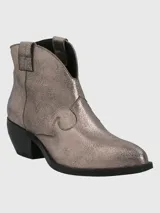 Botín de cuero metalizado color peltre, con puntera fina, laterales con diseño estilo cowboy y taco bajo.