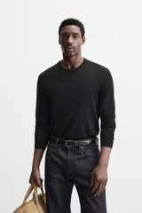 Jersey negro de lana con acabado mercerizado, corte relaxed fit, cuello redondo y manga larga con terminaciones en rib.