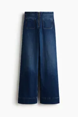 Pantalón de jean de tiro extra alto, color azul oscuro con efecto desgastado sutil. Corte de pierna amplia y recta, con puños anchos doblados. Presenta bolsillos parche cuadrados en la parte trasera y cierre expuesto en la espalda.